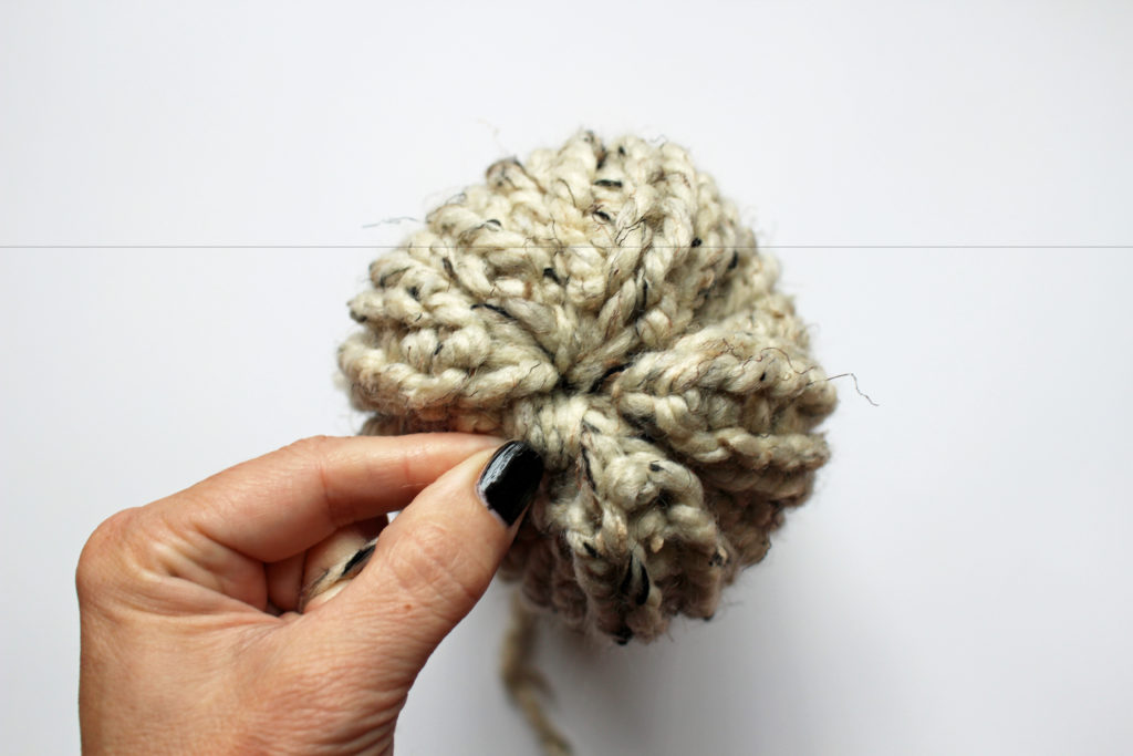 How to cinch the top of a knit hat closed.
